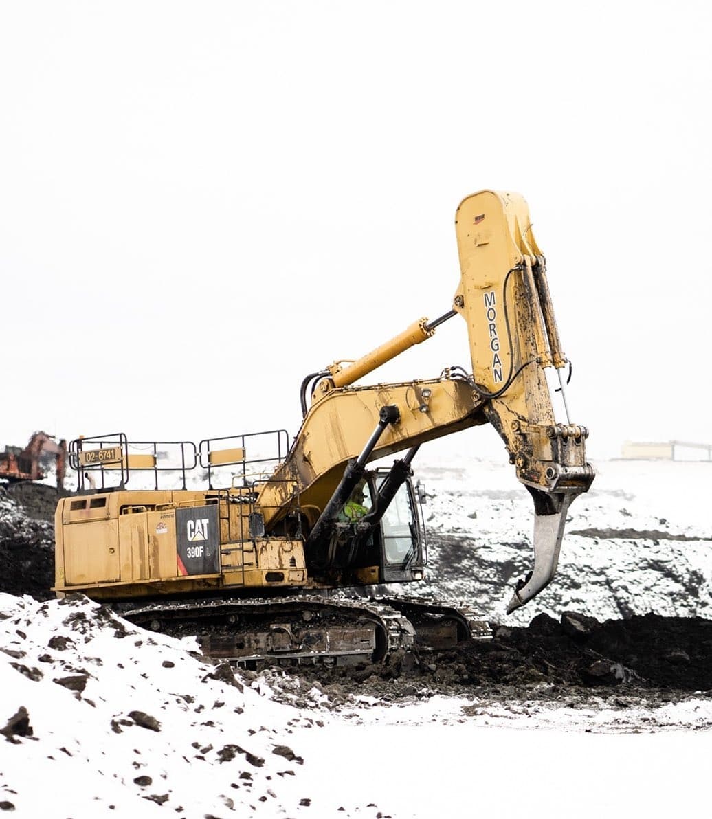 An overexposed photo of a yellow construction machine in winter.